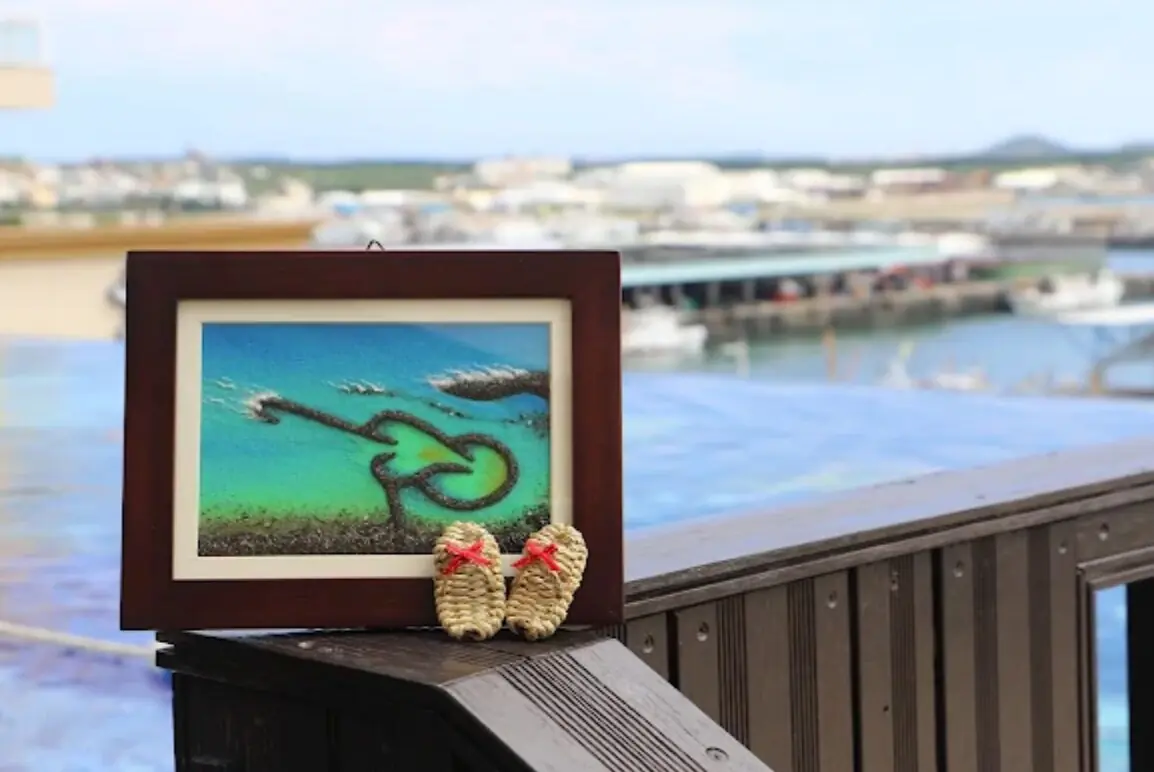 Handcrafted miniature straw sandals displayed with Penghu island imagery